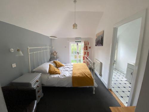 um pequeno quarto com uma cama e uma janela em The Elsted Inn em Trotton