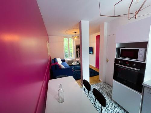 une cuisine avec une table et des chaises dans une pièce dans l'établissement Maison Yuki - Rose Velours - Netflix & Parking, à Le Mont-Dore