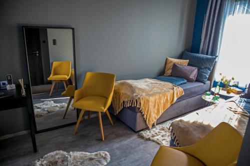 een woonkamer met een bank en een spiegel bij La Róna Rooms in Kiskőrös