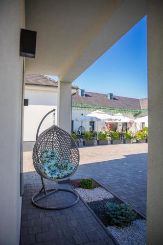 a chair sitting on a patio in a building at La Róna Rooms in Kiskőrös