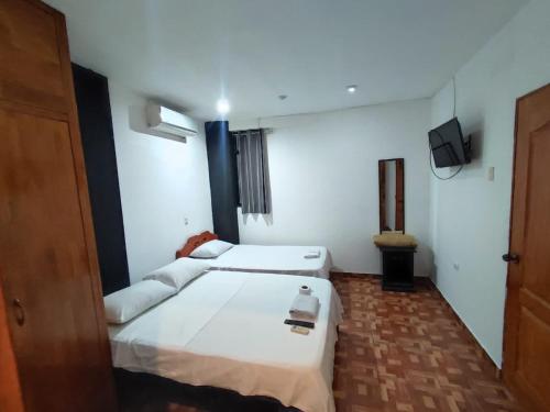 a hotel room with two beds and a television at Hotel A&R in Iquitos