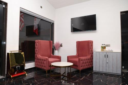 a waiting room with two red chairs and a table at SKD RESORT AND CLUB in Barvāla