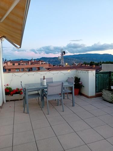 a patio with a table and chairs on a roof at Cal Robert in Tremp