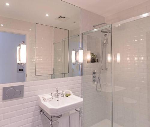 y baño blanco con lavabo y ducha. en Modern, Luxurious 1BR Flat- Heart of Covent Garden, en Londres