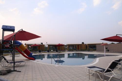 a swimming pool with a slide in the middle at SKD RESORT AND CLUB in Barvāla