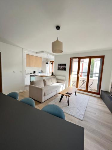 a living room with a couch and a table at Appartement Porte de Paris / Stade de France in Saint-Denis