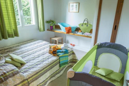 a childs bedroom with a bed and a crib at VVF Haute Loire Haute Ardèche in Tence