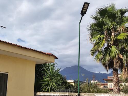 ein Straßenlicht vor einem Haus mit einer Palme in der Unterkunft Il Cortile in Pompei