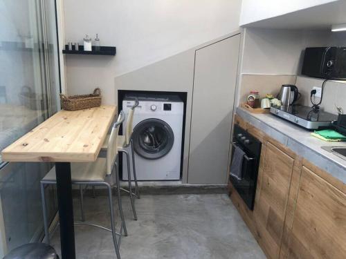 a kitchen with a washing machine and a wooden table at סוויטה על שביל הים in Atlit