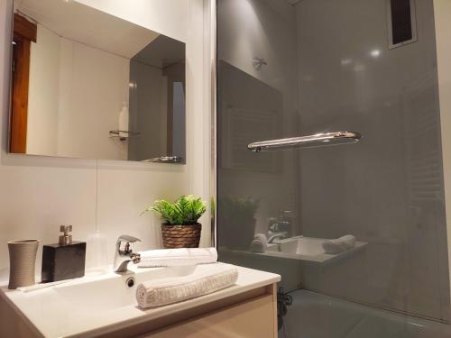 AC Apartaments Suite في باس دي لا كاسا: حمام مع حوض ومرآة