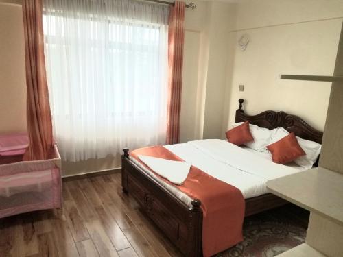 a bedroom with a large bed and a window at Ndemi Garden-One and two bedrooms in Nairobi