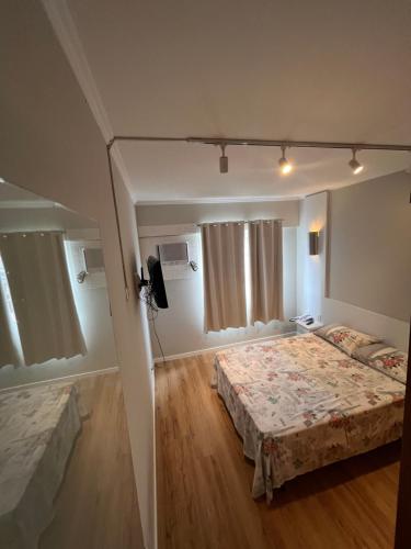 a bedroom with two beds and a television in it at Loft no centro de Joinville in Joinville