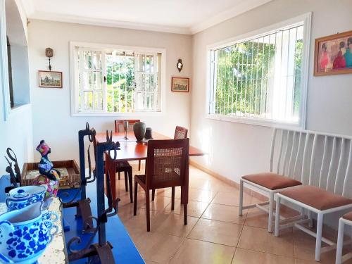 a dining room with a table and chairs and two windows at Casa na praia de Setiba com panorama fantástico in Guarapari