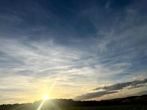 a sun setting in the sky over a field at Ferienwohnung im Usseltal - Zirben Spa - Monheimer Alb - Altmühltal - Familie Geyer Daiting in Monheim