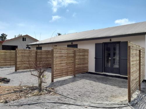 a house with a wooden fence in front of it at LES SOMMETS DE SALAZIE CHAMBRES D'HÔTES in Salazie
