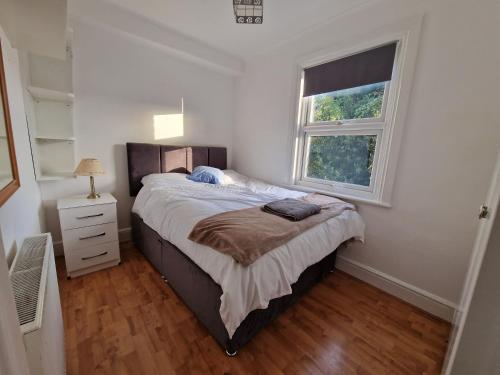 ein Schlafzimmer mit einem großen Bett und einem Fenster in der Unterkunft CosyHomeStay Evesham Spacious home W/Free Parking & WiFi in Evesham