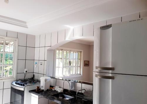 a kitchen with a refrigerator and a counter top at Casa na praia de Setiba com panorama fantástico in Guarapari