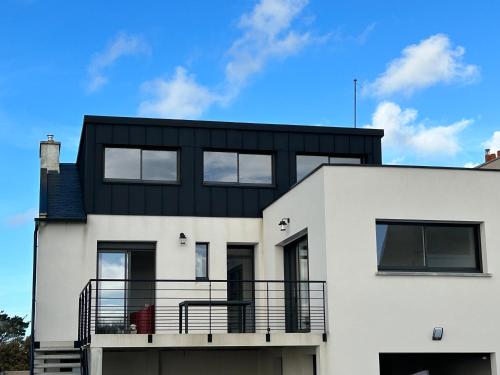 une maison blanche avec un toit noir dans l'établissement TI YANN, à Porspoder