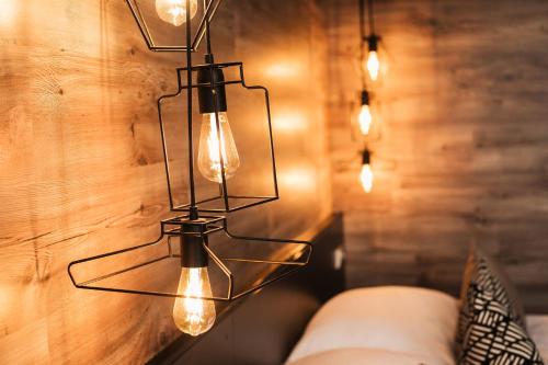 una lámpara de araña con luces colgando de una pared de madera en Interhotel Tatra, en Kopřivnice