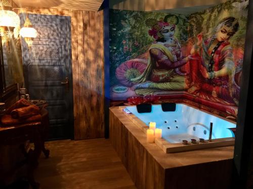 a bathroom with a bath tub with a painting on the wall at Chambre & Spa "La Casa Blue" in Wingles