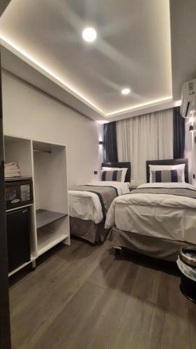 SAND DOOR HOTEL في إسطنبول: غرفه فندقيه سريرين في غرفه
