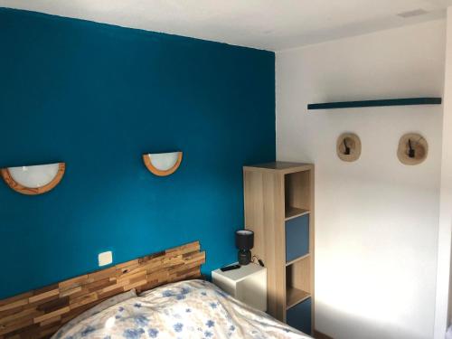 une chambre avec un mur bleu et un lit dans l'établissement Valmeinier - Résidence les Hauts de Valmeinier 4 étoiles avec piscine, à Valmeinier