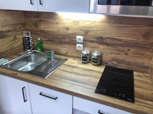 une cuisine avec un évier et un comptoir avec une cuisinière dans l'établissement Valmeinier - Résidence les Hauts de Valmeinier 4 étoiles avec piscine, à Valmeinier