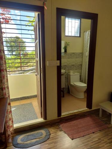 uma casa de banho com um WC, uma banheira e uma janela. em GIFTLAND HOMESTAY em Āīzawl