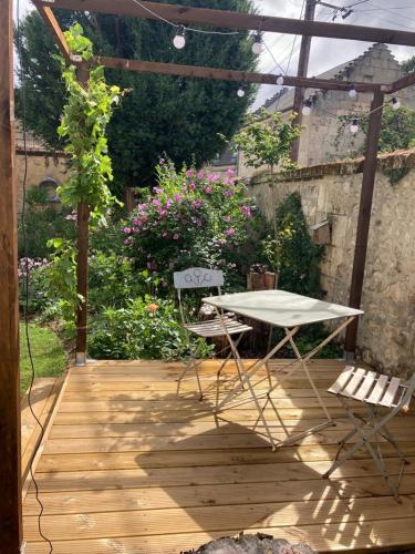 a table and two chairs on a wooden deck at Le bois de mon coeur - studio cosy indépendant in Villeneuve-Saint-Germain
