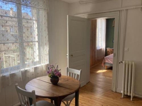 a room with a table and chairs and a window at Le bois de mon coeur - studio cosy indépendant in Villeneuve-Saint-Germain