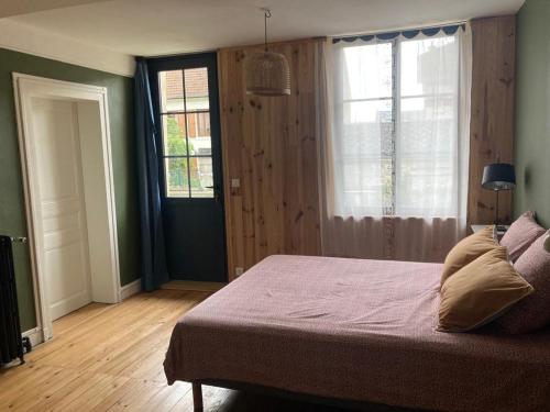 um quarto com uma cama grande e uma janela em Le bois de mon coeur - studio cosy indépendant 