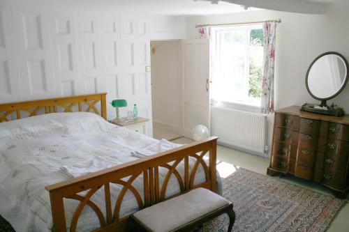 1 dormitorio con cama, espejo y tocador en Stable Lodge B&B, en Petham
