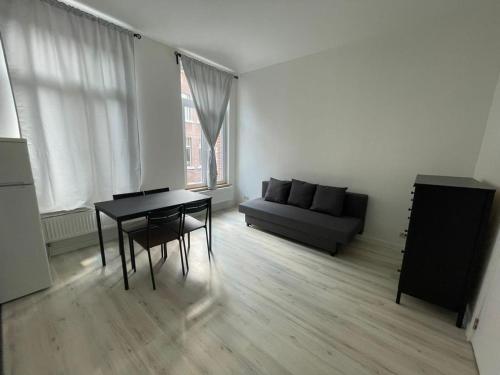 uma sala de estar com uma mesa preta e um sofá em Apartament Brussels 2 em Bruxelas