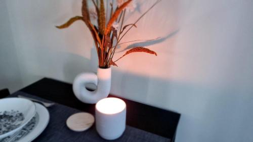 a candle and a vase with a plant on a table at Cozy Riverside Pine Studio E5 in Borovets