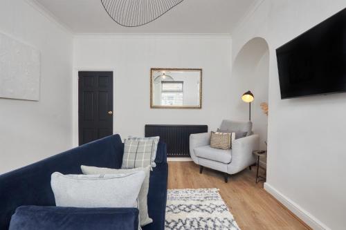 達靈頓的住宿－The Derwent，客厅配有蓝色的沙发和两把椅子