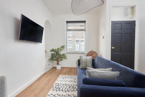 ein Wohnzimmer mit einem blauen Sofa und einem Fenster in der Unterkunft The Derwent in Darlington