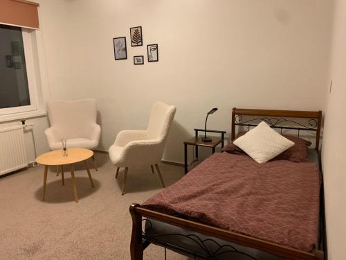 a bedroom with a bed and two chairs and a table at Apartmán Vsetín Rokytnice in Vsetín