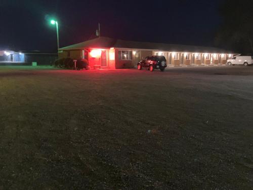 a car parked in front of a building at night at Tops Motel in Burley