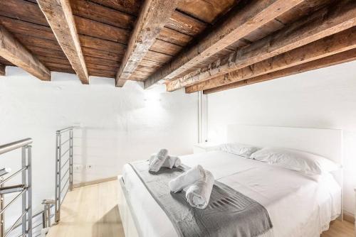 um quarto com uma cama branca e toalhas em Duomo 10 minutes away - Loft with Wifi and Netflix em Milão