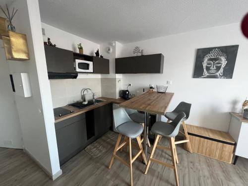 une petite cuisine avec une table et des chaises en bois dans l'établissement Cosy Studio, à Fréjus