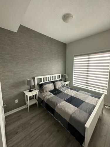 um quarto com uma cama grande e uma janela em Modern Townhouse, Vaughan, Ontario, Canada em Vaughan