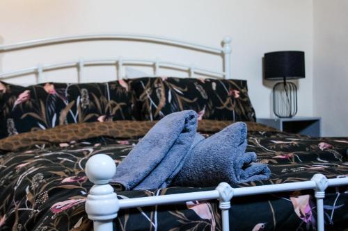 a bed with two blue towels sitting on it at The Brown Box Holiday Let in Loftus