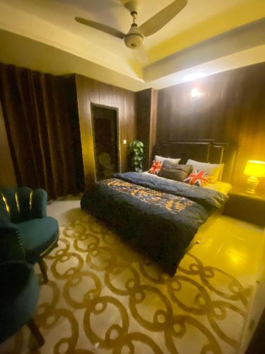 um quarto com uma cama e uma cadeira azul em Viceroy Executive Hotel Apartments Islamabad em Islamabad