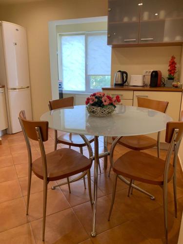 uma cozinha com uma mesa e cadeiras com uma tigela de flores em Apartament Crăciunița em Timisoara