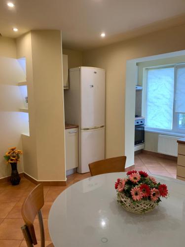 a kitchen with a white table with flowers on it at Apartament Crăciunița in Timişoara