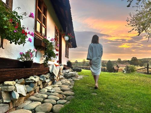 a woman walking down a path towards a house at Садиба Гардига in Pistyn