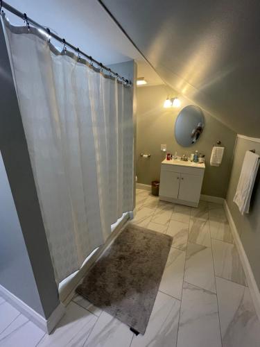 uma casa de banho com uma cortina de chuveiro e um piso de azulejo em Cape Cod Loft - Room near Liberty! em Lynchburg