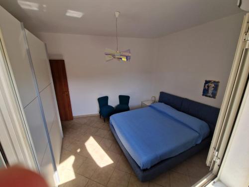 - une chambre avec un lit bleu et deux chaises bleues dans l'établissement A&M Home, à Letojanni