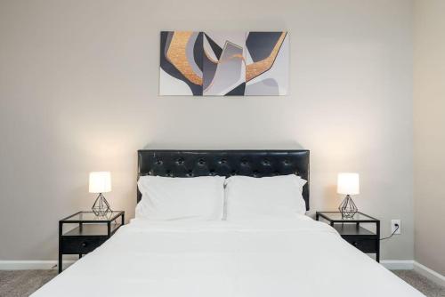um quarto com uma grande cama branca com duas mesas de cabeceira em Private Room Greenwood - Shared em Greenwood