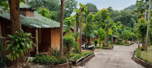 a street in a village with a motorcycle parked next to a building at ลิ้นฟ้าแคมป์ปิ้งรีสอร์ท in Mae Hong Son